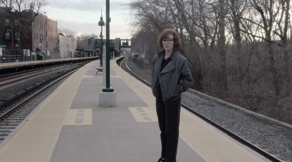 Paige (Holly Taylor) standing on the train platform after abandoning her parents. 